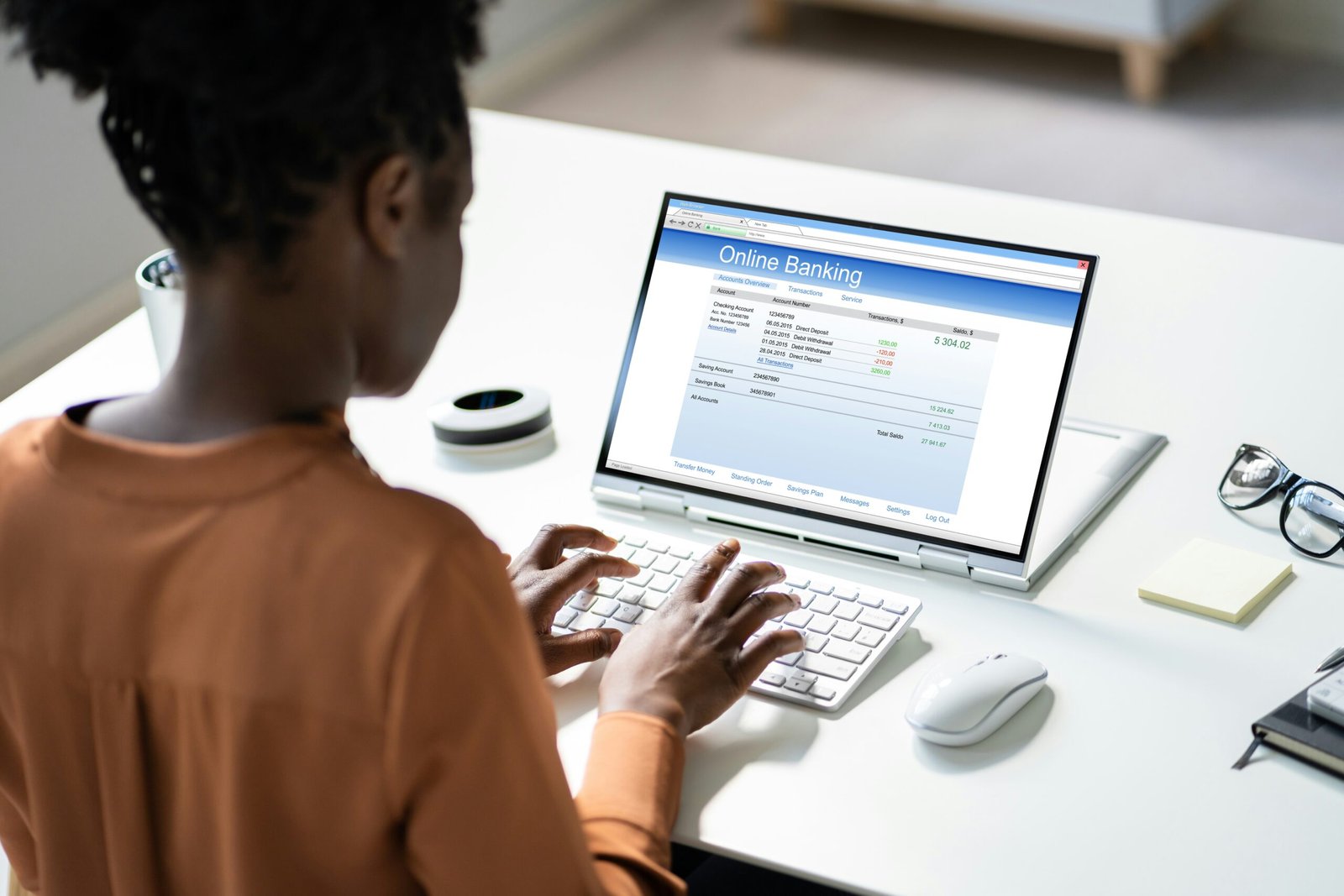 Woman calculating her banking with a computer saying online banking